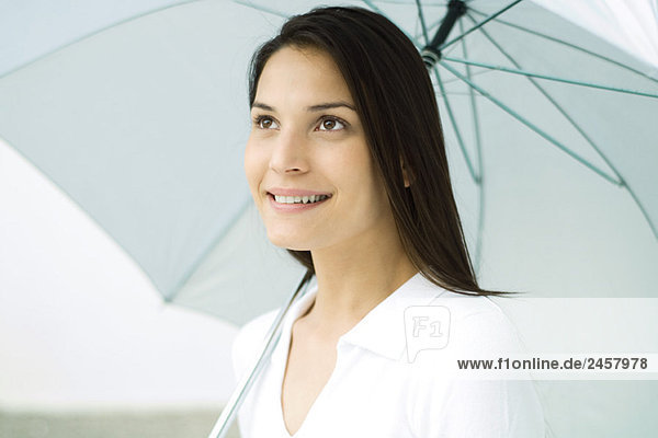 Frau hält Schirm  lächelnd  Portrait