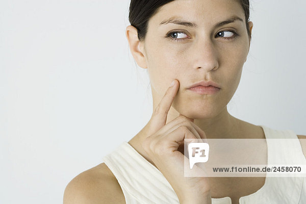 Woman looking away  hand under chin