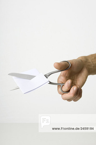 Hand mit der Schere zum Schneiden von Papier
