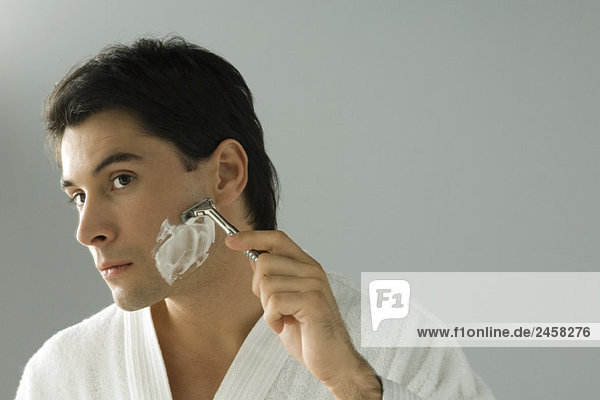 Mann rasieren  Bademantel tragen  Kopf geneigt