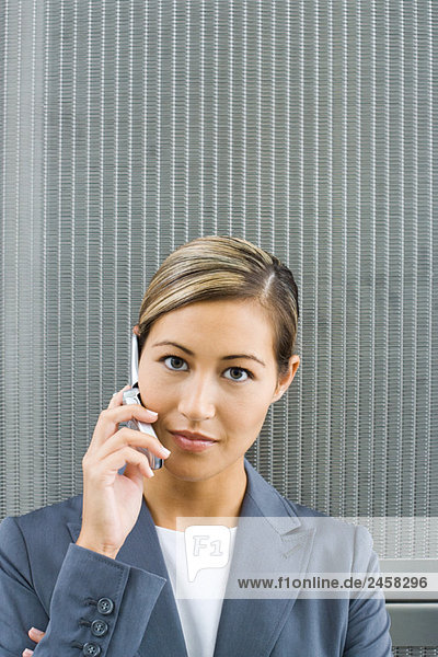 Woman using cell phone  looking at camera  portrait