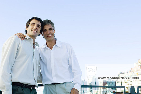 Man with his arm around another man  smiling at camera  portrait