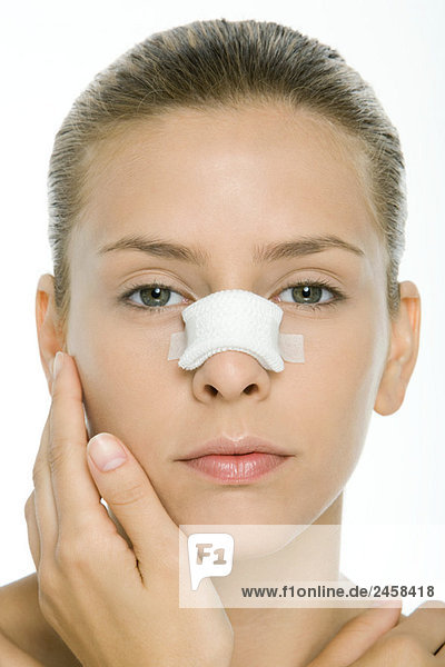 Frau mit bandagierter Nase  Blick in die Kamera  Porträt