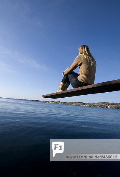 Eine Frau sitzt auf einer Tauchen-Board Bohuslan Schweden.