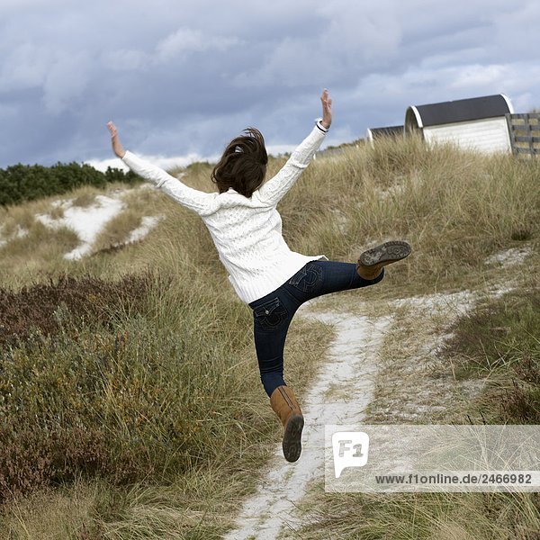 A young woman jumping Skane Sweden.