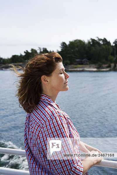 A woman on a boat a sunny summers day the archipelago of Stockholm Sweden.
