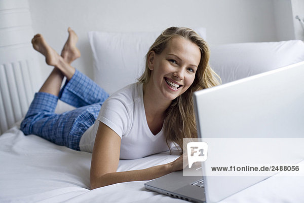 Frau liegen auf dem Bett mit laptop