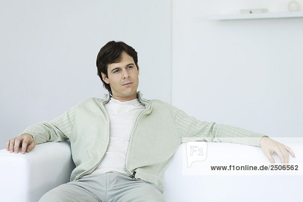 Man relaxing on couch  looking away