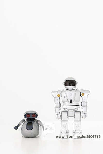 Spielzeugroboter mit Blick auf die Kamera  Seite an Seite