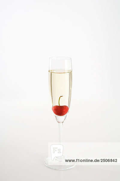 Kirsche schwimmend im Glas Champagner