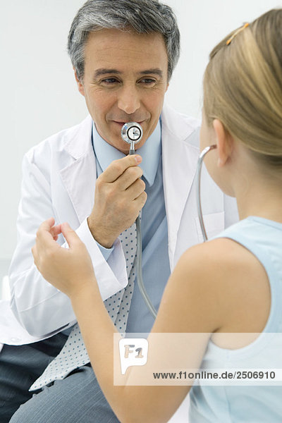 Kinderarzt beim Stethoskopieren  Mädchen beim Zuhören