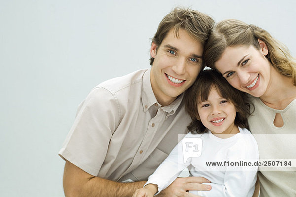 Young parents with little boy  smiling at camera  portrait