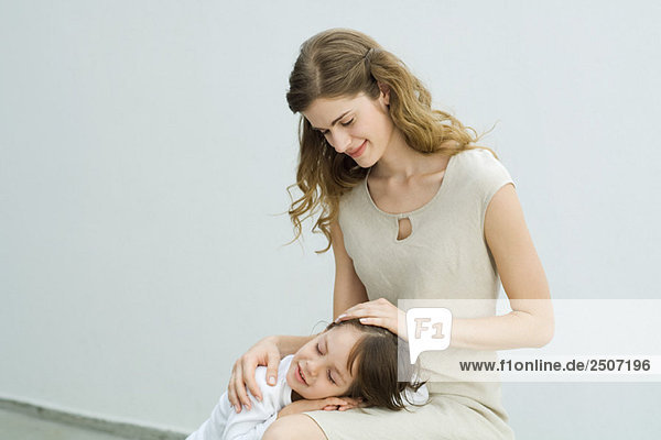 Kleiner Junge ruht Kopf auf dem Schoß der Mutter  Frau streichelt Kinderhaar