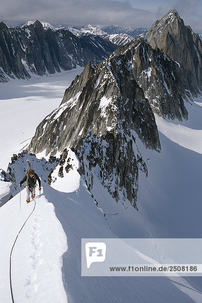 Mountaineer climbing on narrow ridge in Kichatna Mtns Denali National Park Interior Alaska Winter