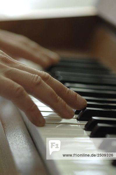 Close-up of a ma's hands playing piano