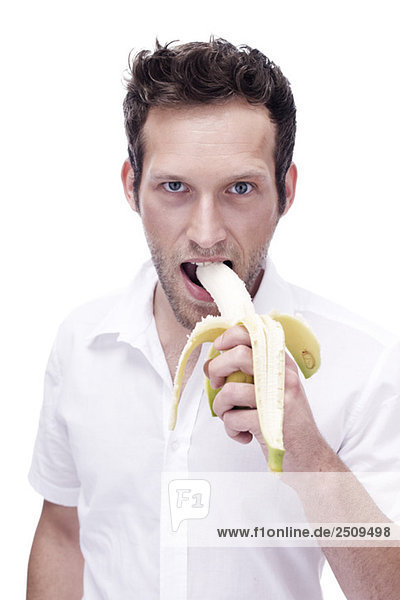 Porträt eines jungen Mannes beim Essen einer Banane