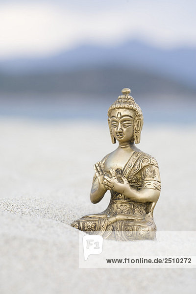 Buddha-Figur auf Sand  Nahaufnahme