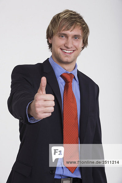 Young businessman  thumbs up  smiling