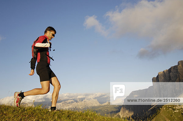 Side profile of mid adult man running on landscape  Trentino-Alto Adige  Italy