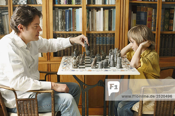 Vater spielt Schach mit kleinem Jungen