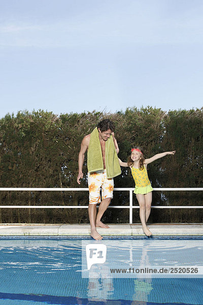 Vater und Mädchen beim Zehentauchen im Pool