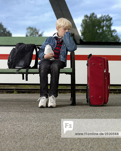 Junge wartet am Bahnhof