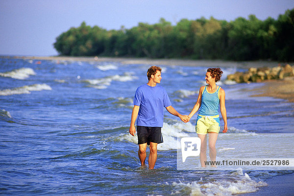 Couple walking along Beach  Lake Winnipeg  Manitoba.
