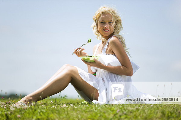 Junge Frau isst Gemüse