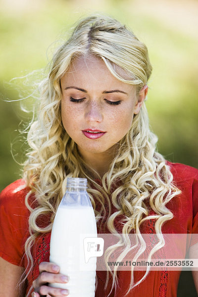 Junge Frau mit einer Milchflasche
