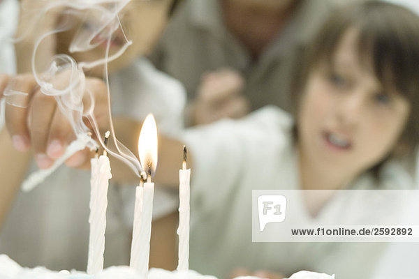 Junge greift nach Kerzen auf Geburtstagskuchen  Fokus auf Vordergrund