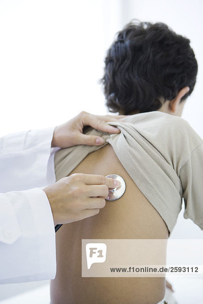 Arzt platziert Stethoskop auf dem Rücken des Jungen  Schnittansicht