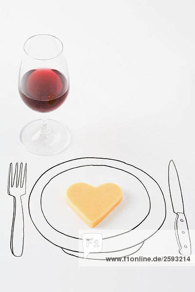 Herzförmiger Käse auf Tellerzeichnung  Glas Rotwein in der Nähe