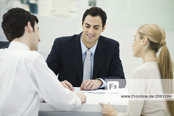 Meeting between professional and clients  together reviewing document