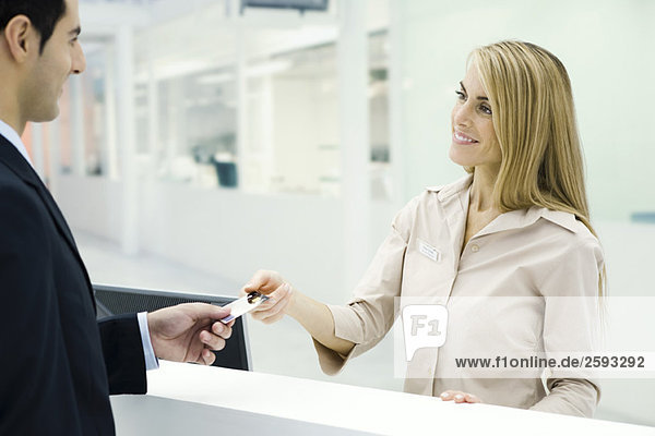 Customer handing credit card to customer service representative