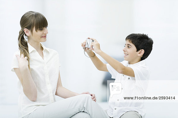 Boy taking photo of young woman  side view