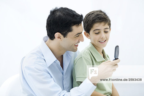 Father and son looking at cell phone together