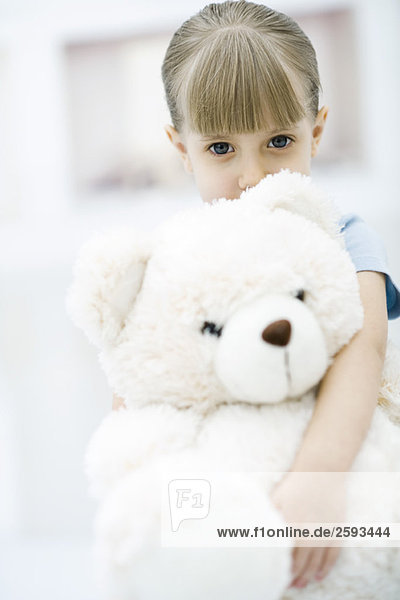 Little girl holding large teddy bear  portrait
