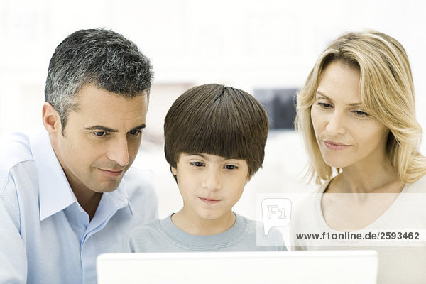 Family looking at laptop computer together  close-up