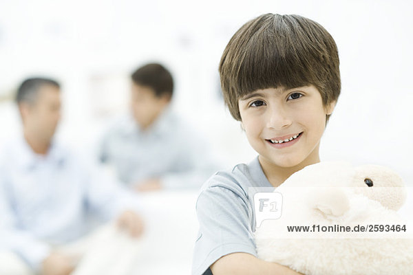 Boy holding stuffed toy  smiling  portrait
