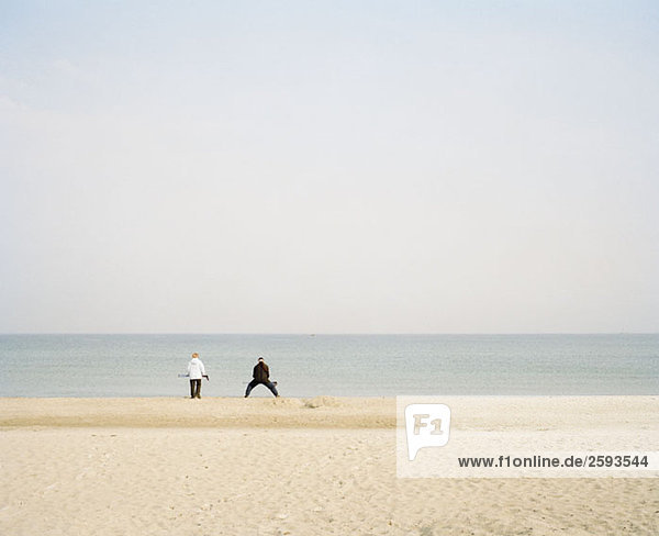 Ein Strand an der Ostsee  Deutschland mit zwei unerkennbaren Menschen in der Ferne.