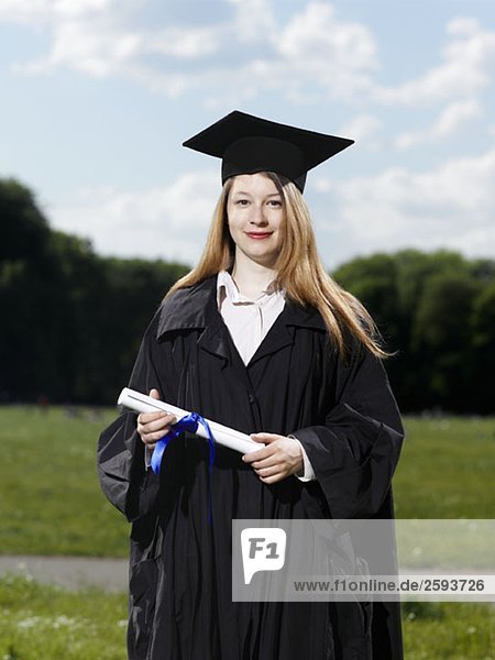 A female graduate holding a diploma