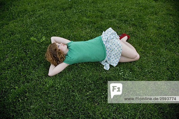 Eine junge Frau auf Gras liegend
