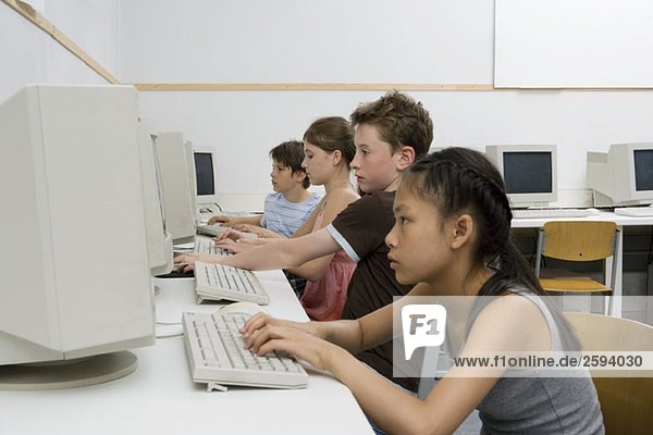 Vier vorjugendliche Kinder in einem Computerlabor