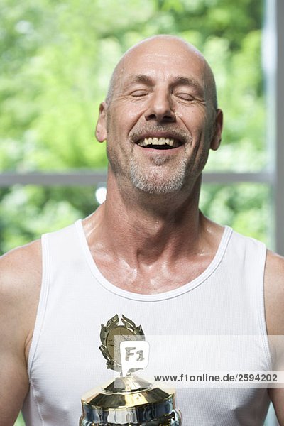 Ein Mann mit einer Trophäe für Gymnastik