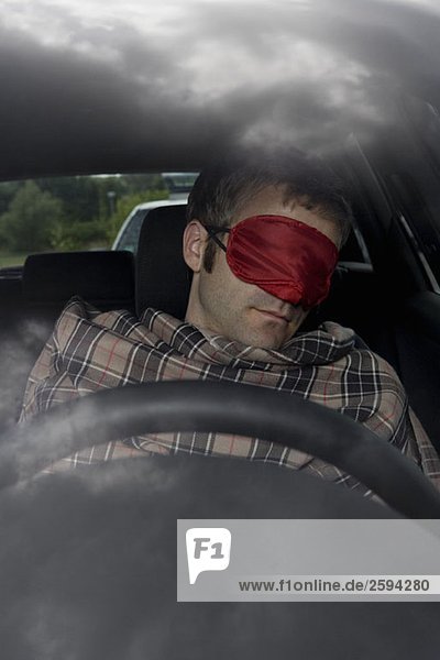 A man sleeping in a car