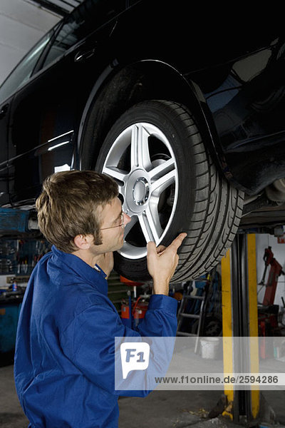 A mechanic fixing the wheel of a car in a repair garage
