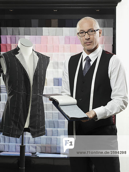 A tailor holding fabric swatches