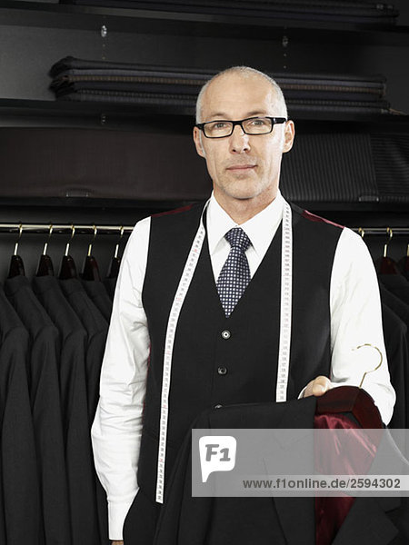 A tailor holding a jacket