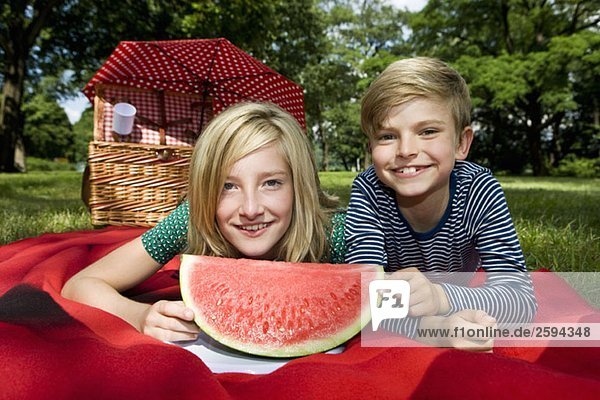 Zwei Kinder mit einer Scheibe Wassermelone