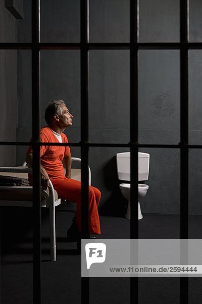 Ein Gefangener  der in seiner Zelle sitzt.